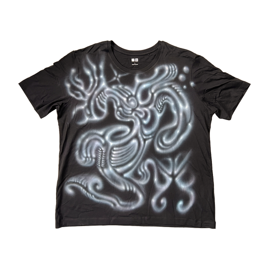 Black t-shirt with a glowing white alien design on a white background