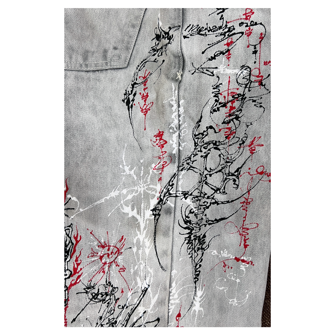 Gray denim jacket with black and red abstract designs on a white background
